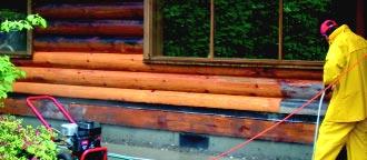S-100 finish remover application - worker pressure washing log home stain